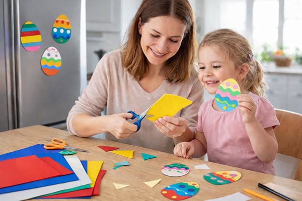 Mutter und Kind fertigen Osterdekorationen an